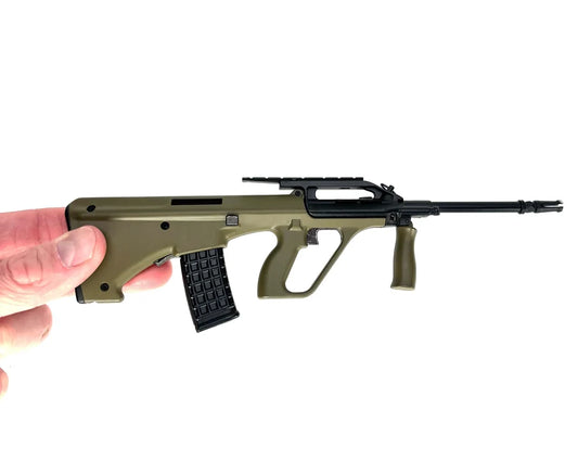Bullpup Geardo green miniature model held between fingers, side view