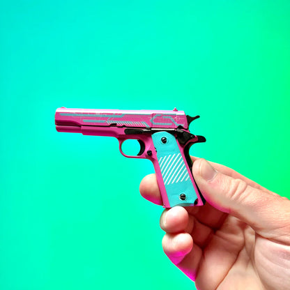 Side view of pink and turquoise 1911 Edge Runner miniature model held in hand